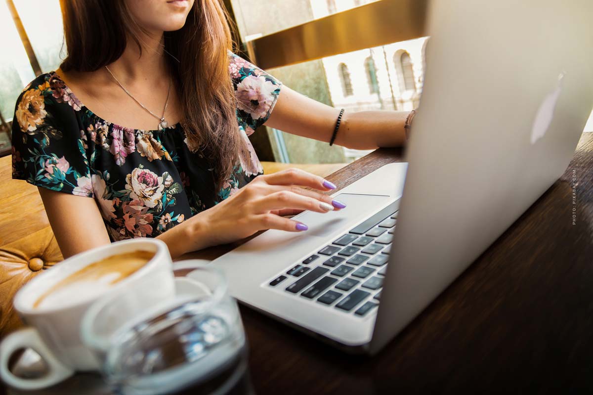 modelagentur-job-vollzeit-international-model-manager-frau-notebook-cafe-reisen-planung-casting-mailand